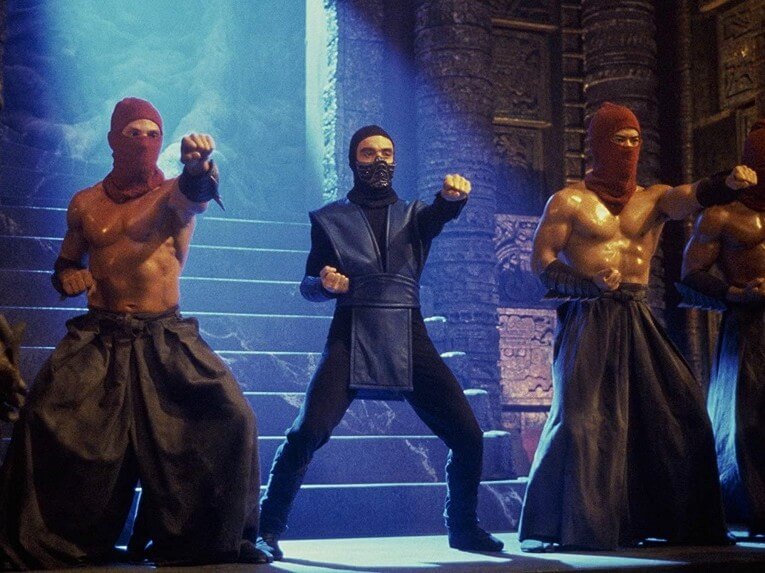 Tiga karakter dalam film Mortal Kombat (1995) sedang berpose kuda-kuda sebelum bertarung